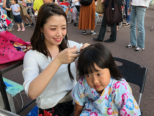 町内会のお祭りでヘアアレンジをする様子